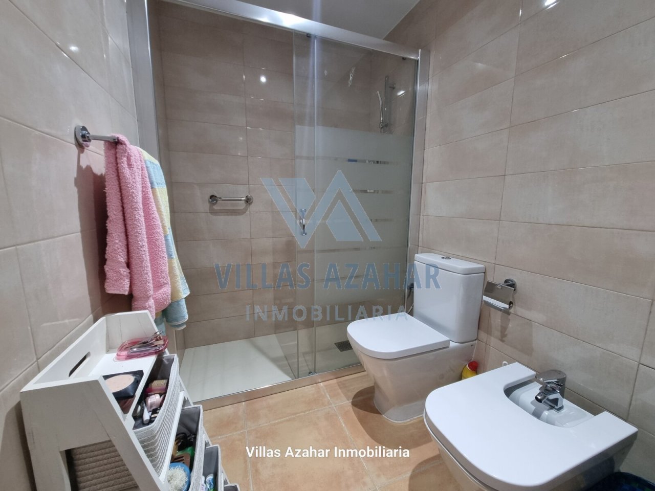 Baño moderno con comodidad: ducha de vidrio elegante, muebles de almacenamiento prácticos y equipamiento sanitario de alta calidad