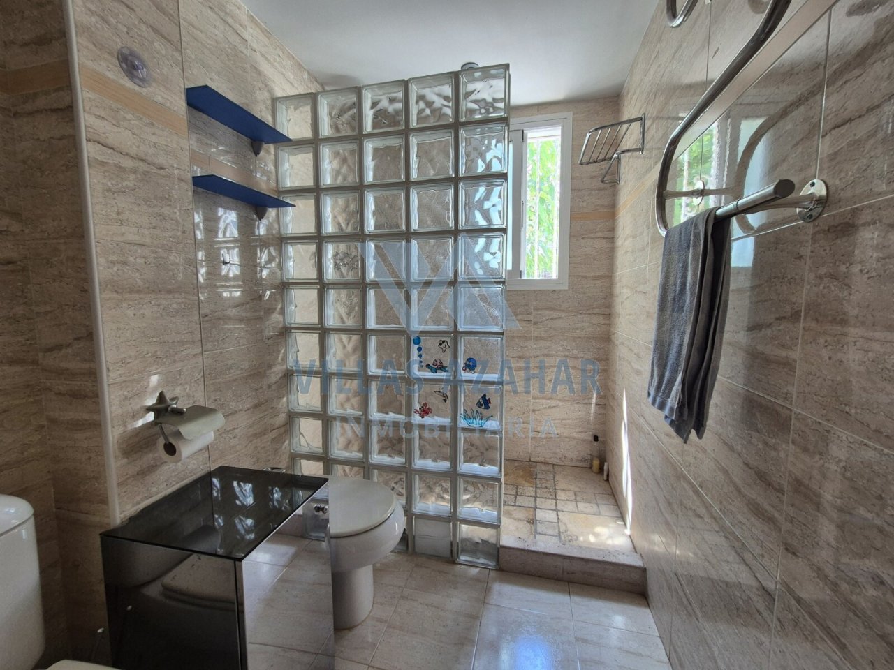 Oasis de bienestar luminosa: baño moderno con elementos de vidrio de diseño y luz natural