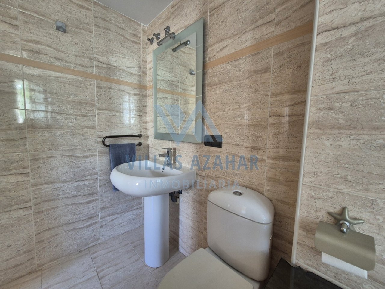 Baño exclusivo para invitados con aspecto de piedra natural y equipamiento moderno